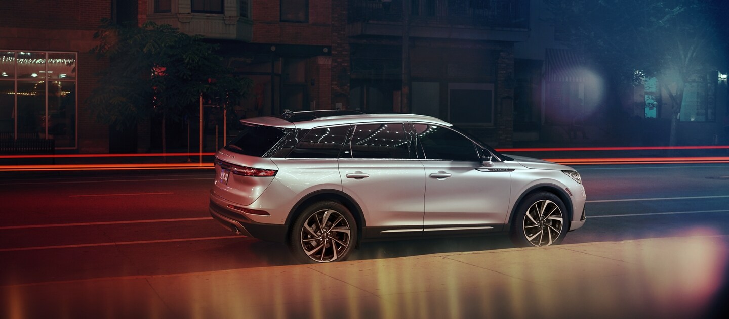 A 2023 Lincoln Corsair SUV is parked in a city setting at night