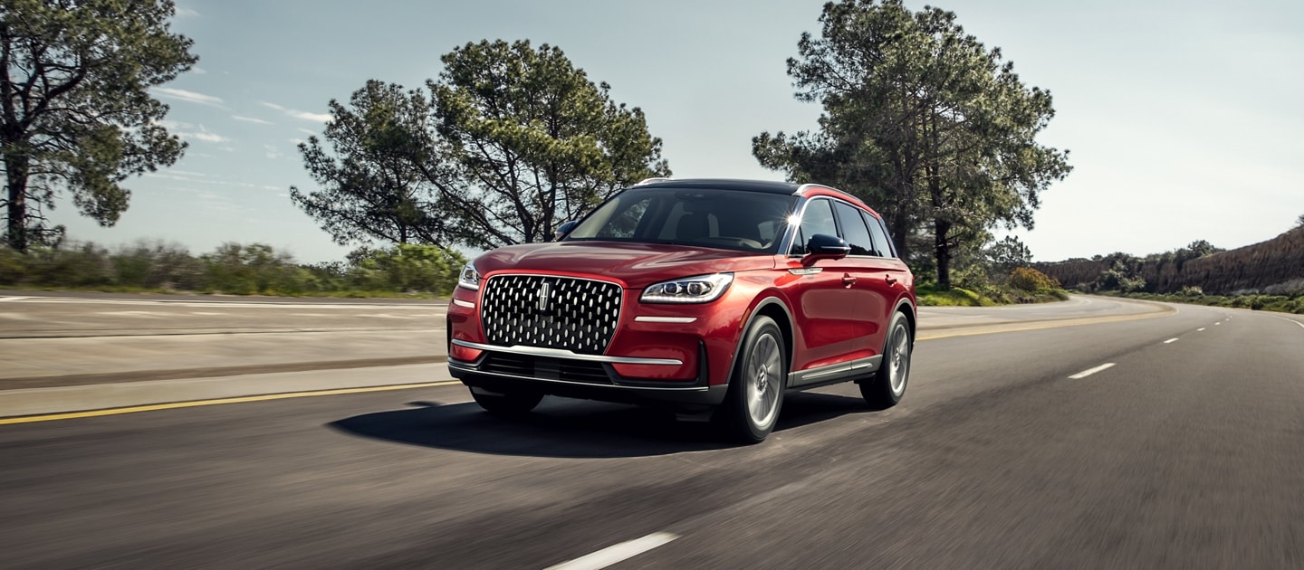 A 2024 Lincoln Corsair SUV is being driven on a coastal highway