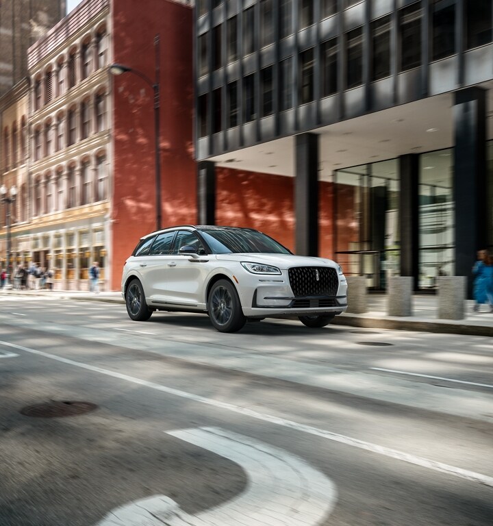 A 2024 Lincoln Corsair SUV with the Jet Appearance Package is being driven in the city