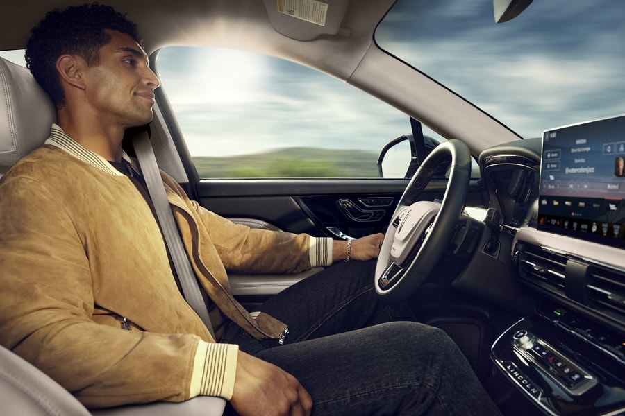 A person shown in the driver’s seat of a 2024 Lincoln Corsair while using Lincoln BlueCruise