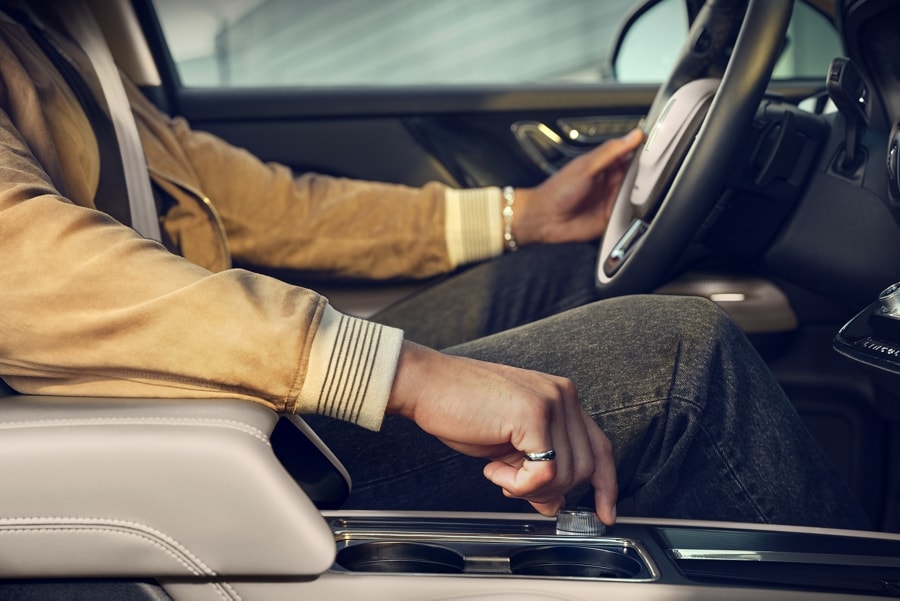 Through the window of a 2024 Lincoln Corsair SUV we see a hand turning the drive modes knob