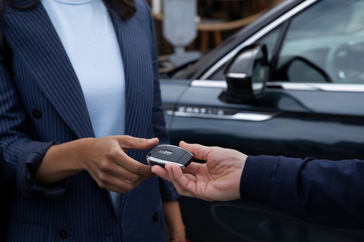 A Lincoln representative hands a customer a set of keys