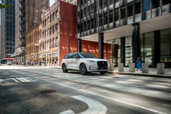 A 2025 Lincoln Corsair with the Available Jet Appearance Package is being driven in a city setting