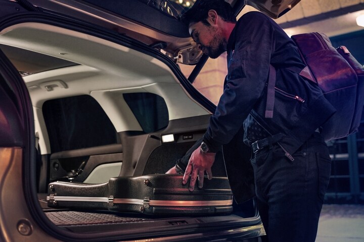 A musician loads musical equipment in the rear cargo area of a 2025 Lincoln Corsair