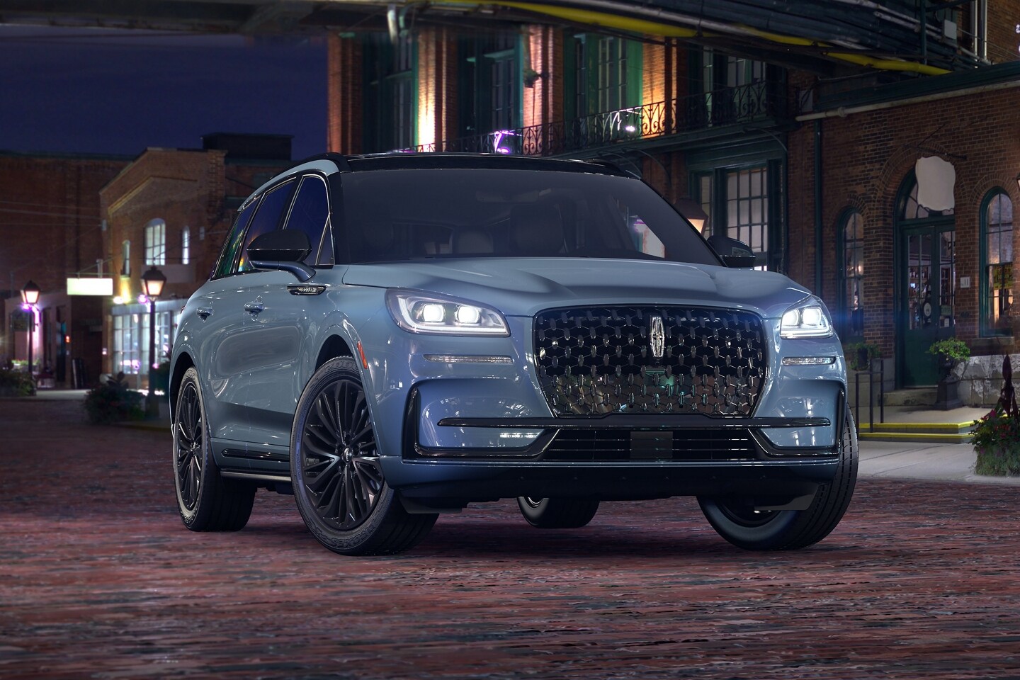 A 2025 Lincoln Corsair Grand Touring plug-in hybrid with the available Jet Appearance Package is parked in a city at night