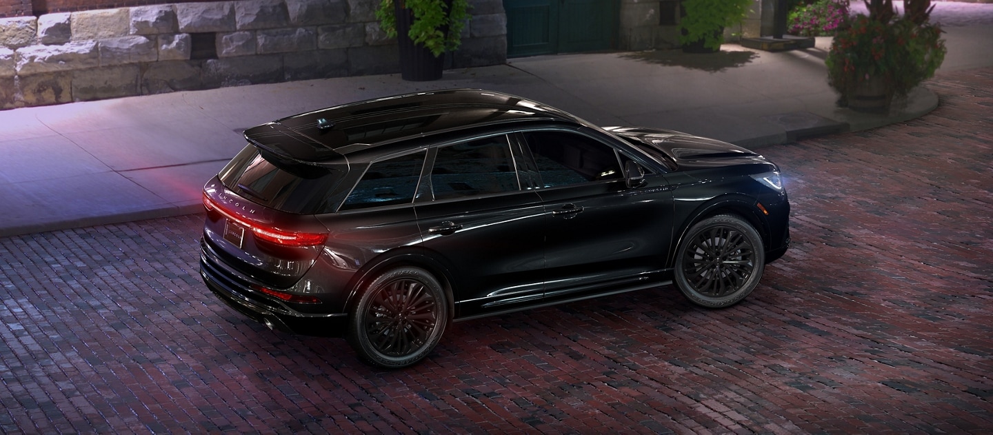 A 2025 Lincoln Corsair is parked on a brick street at night