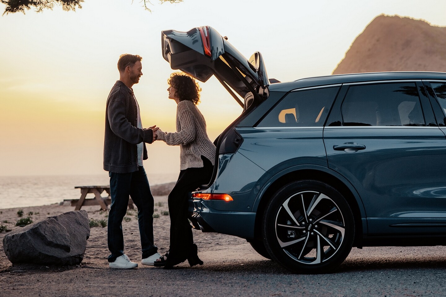 A woman sits in the rear of a 2025 Lincoln Corsair SUV with the rear liftgate open