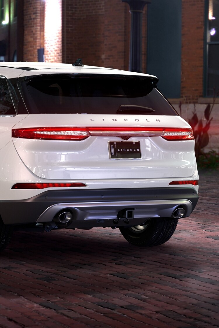 The rear of a 2026 Lincoln Corsair Premiere model is shown with a trailer hitch attached