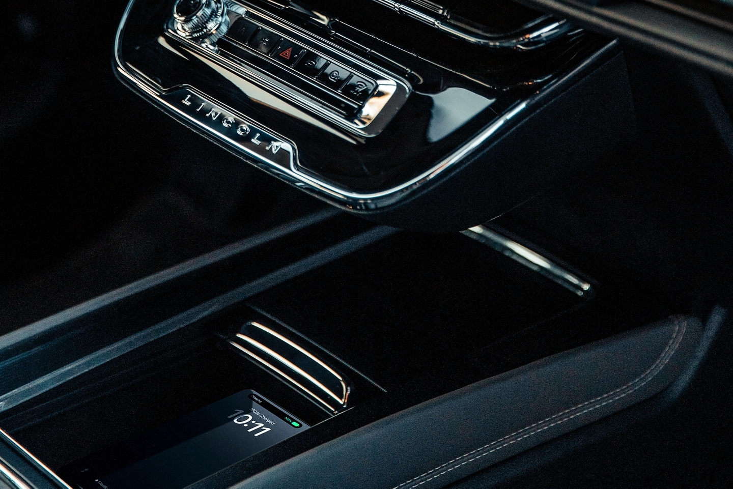 A mobile phone rests on the available wireless charging pad inside a 2026 Lincoln Corsair SUV