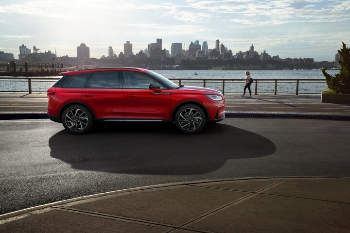 A 2026 Lincoln Corsair in the Red Carpet exterior colour is parked next to a waterside park