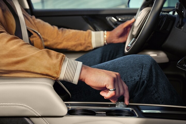 A hand of a person driving a 2026 Lincoln Corsair is shown turning a centre knob to switch drive modes