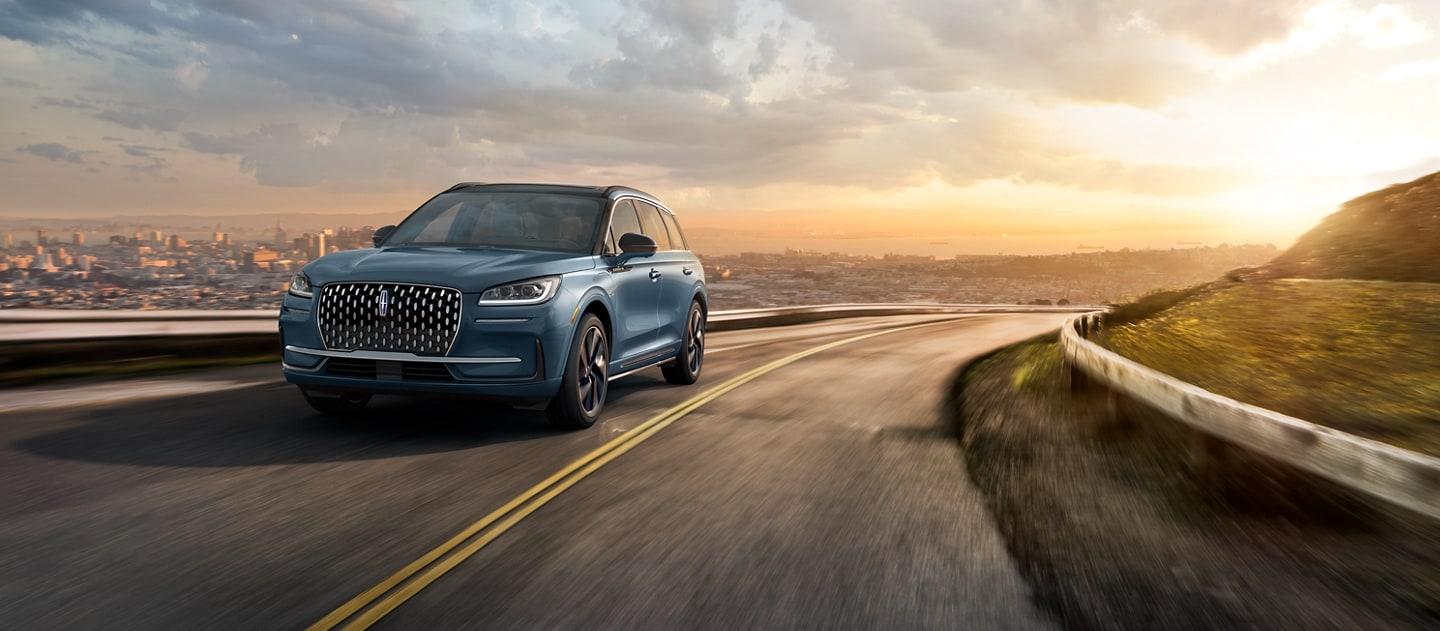 A 2026 Lincoln Corsair Grand Touring Plug-in Hybrid model is being driven on a mountain road