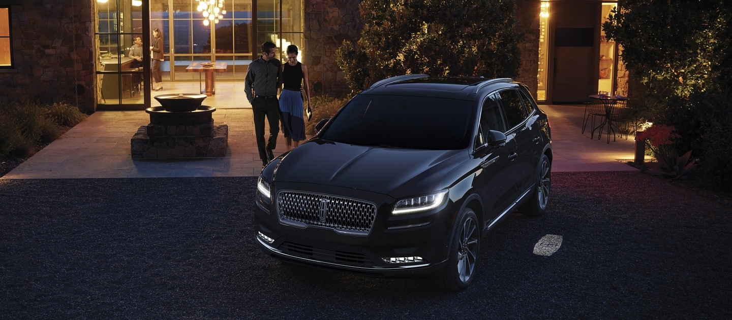 Couple at their home with a parked Lincoln Canada Nautilus