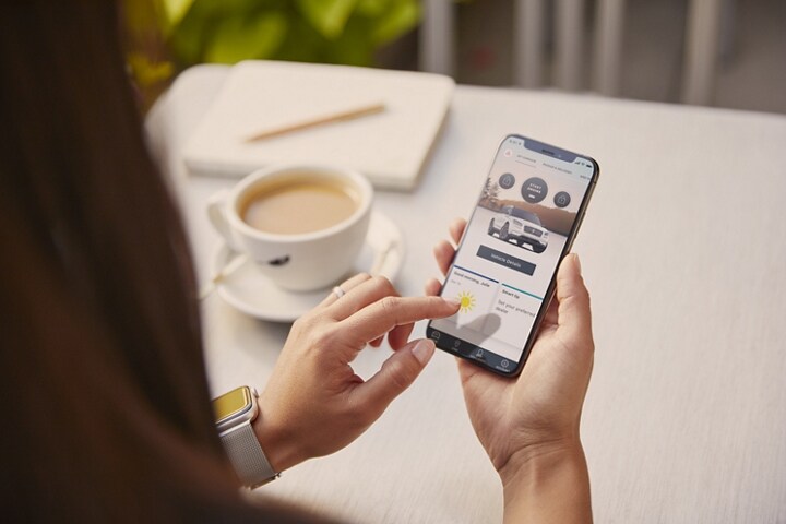A young woman is interacting with the Lincoln Way™ app on her smartphone
