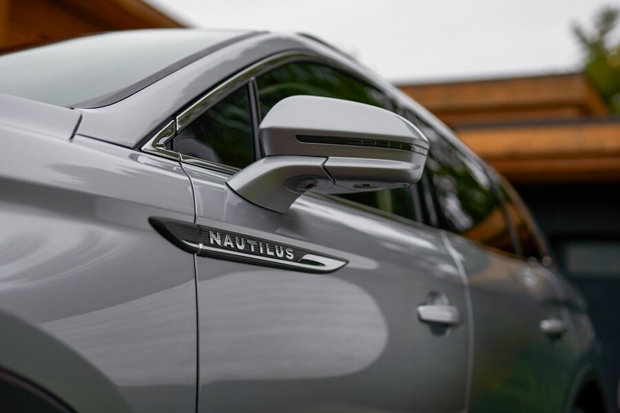 A close-up shot of a 2023 Lincoln Nautilus SUV shows the driver’s side mirror