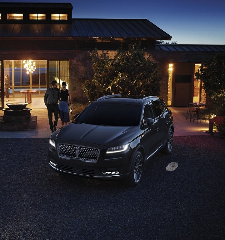A 2023 Lincoln Nautilus SUV illuminates as a couple approaches the vehicle