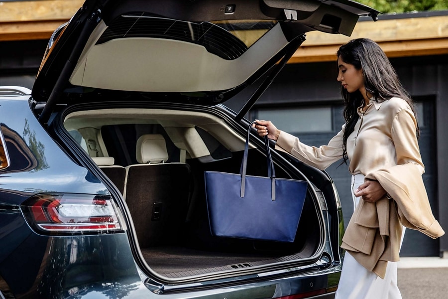 A person uses the hands-free liftgate on the 2023 Lincoln Nautilus Reserve SUV and places a bag in the rear cargo area