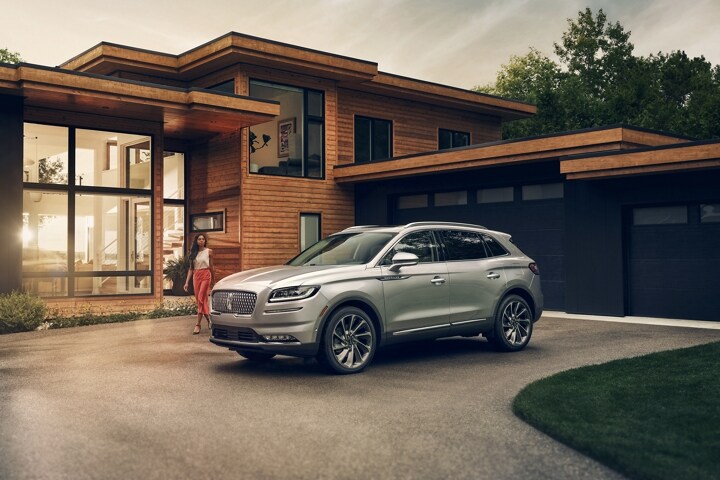 A woman is approaching a 2023 Lincoln Nautilus SUV in Silver Radiance