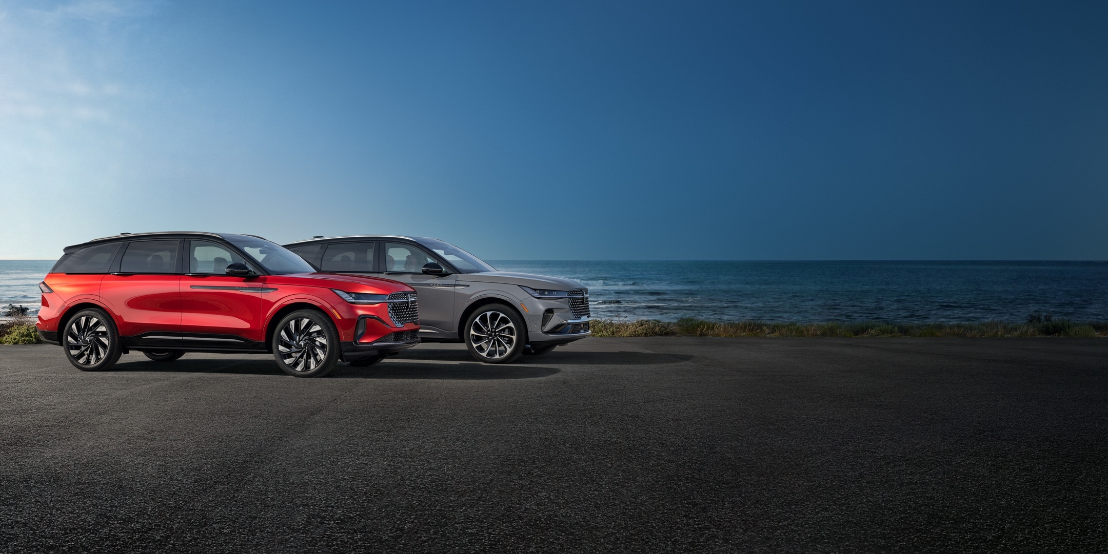 Two 2024 Lincoln Nautilus SUVs are parked on a seashore overlook