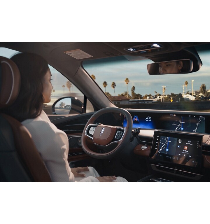 A driver of a 2025 Lincoln Nautilus SUV is shown using hands-free Lincoln BlueCruise technology on a divided highway