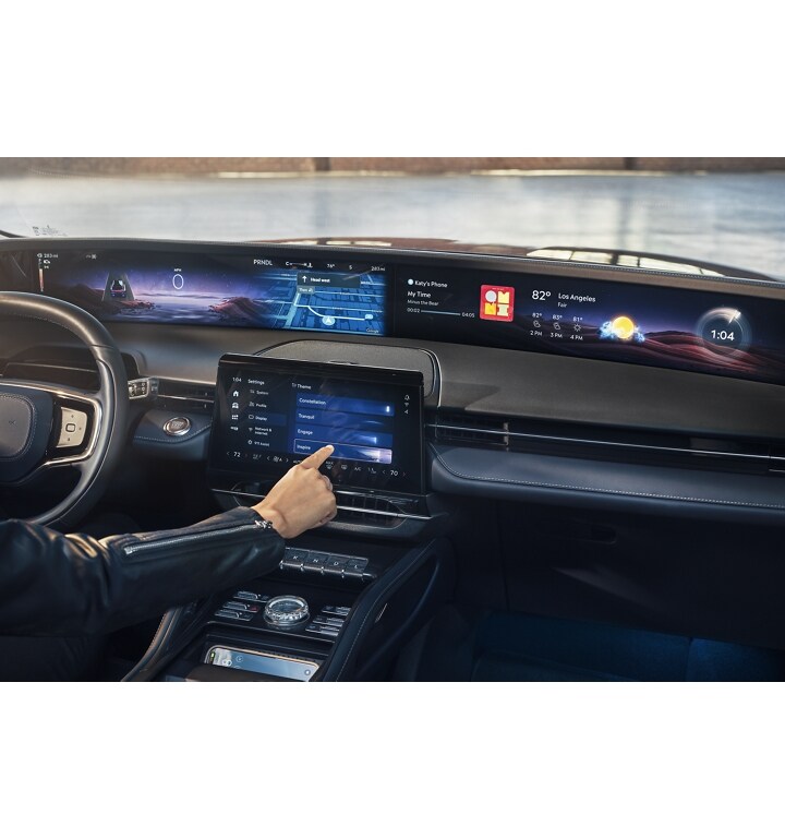 The driver of a parked 2025 Lincoln Nautilus SUV adjusts the display theme that appears in the panoramic display