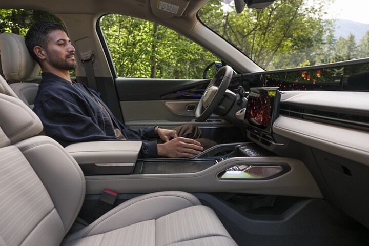 A person enjoys Lincoln Embrace while seated in the driver's seat of a parked 2026 Lincoln Nautilus