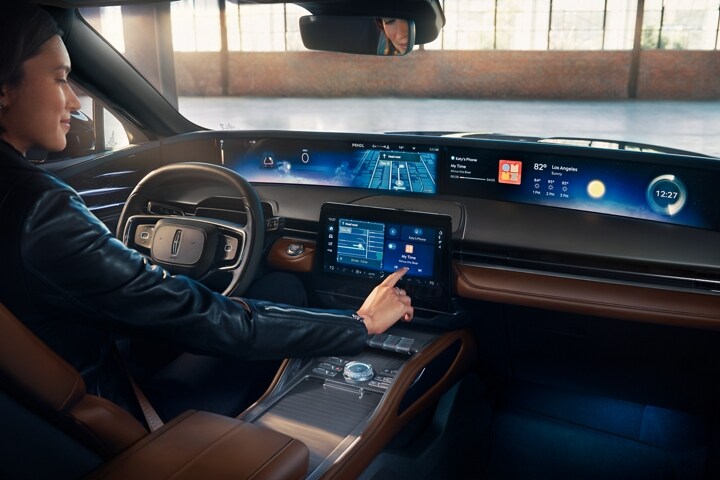 A woman interacts with the centre touchscreen of a 2026 Lincoln Nautilus