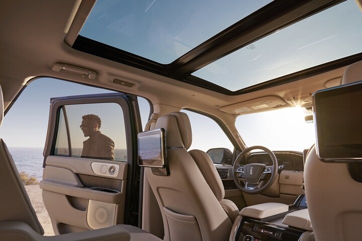 Blue skies are shown through the windows and the Vista Roof as Rear Seat Entertainment screens mounted on the backs of seats reflect the surroundings