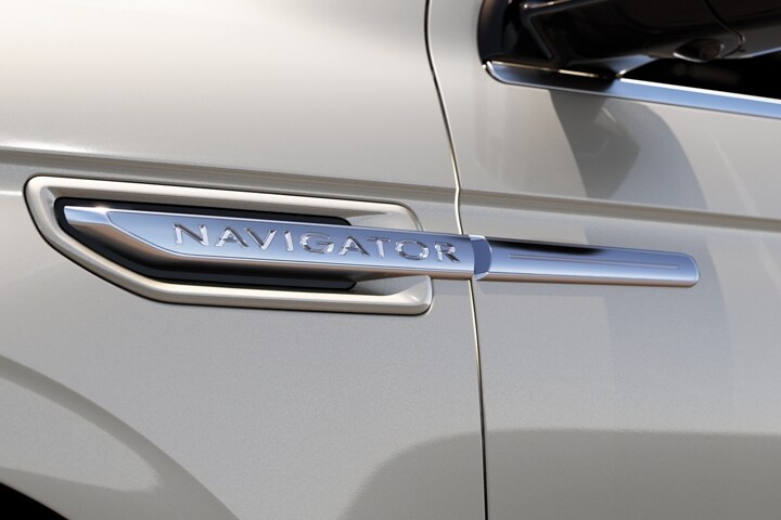 A close up of the chrome on a 2021 Lincoln Navigator badge above the front wheel well draws the eyes along the movement of horizontal design lines
