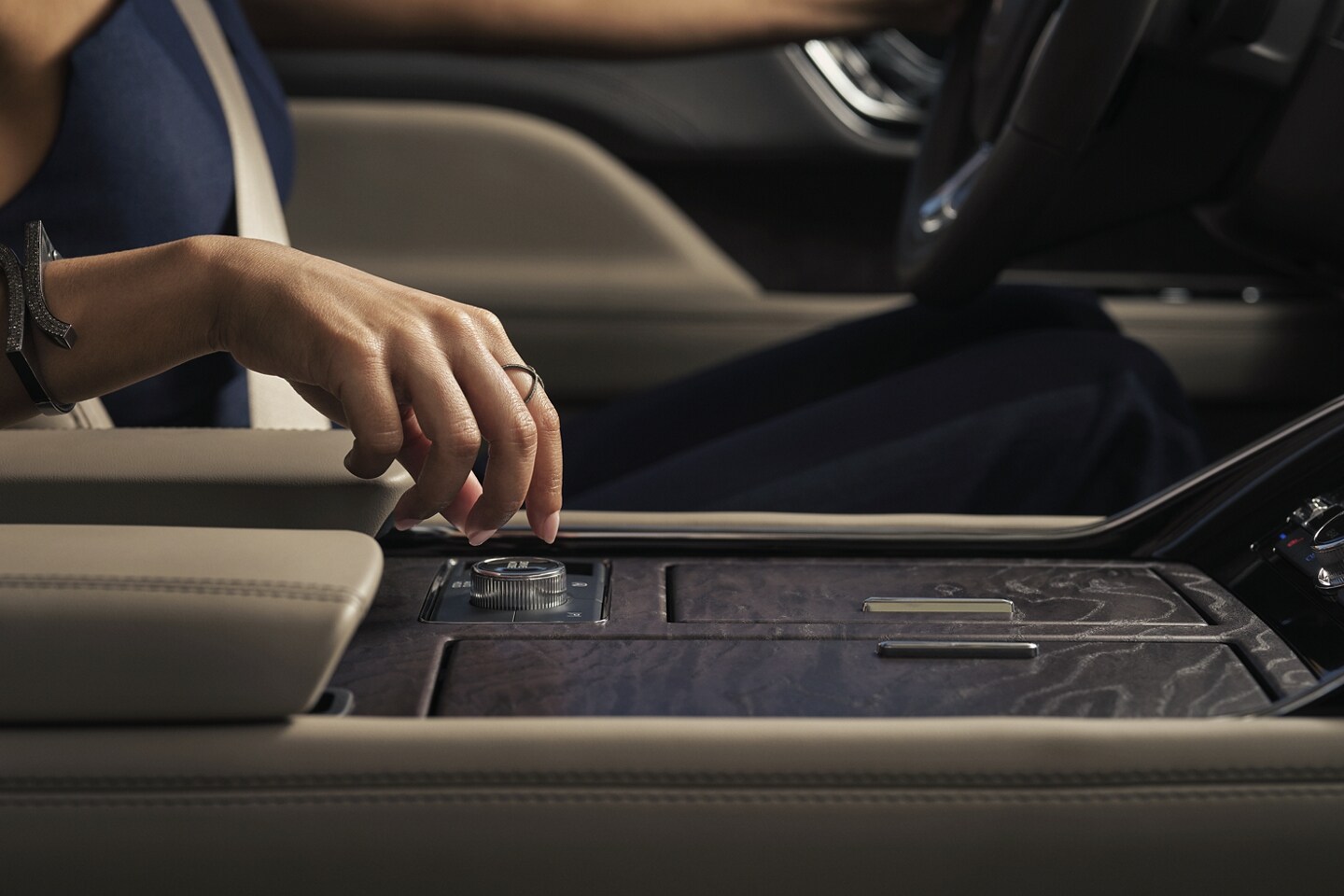 A hand is turning the Lincoln Drive Modes knob inside a 2024 Lincoln Navigator SUV