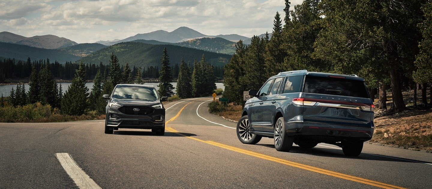 A 2023 Lincoln Navigator® SUV is making a left turn as another vehicle approaches from the other lane