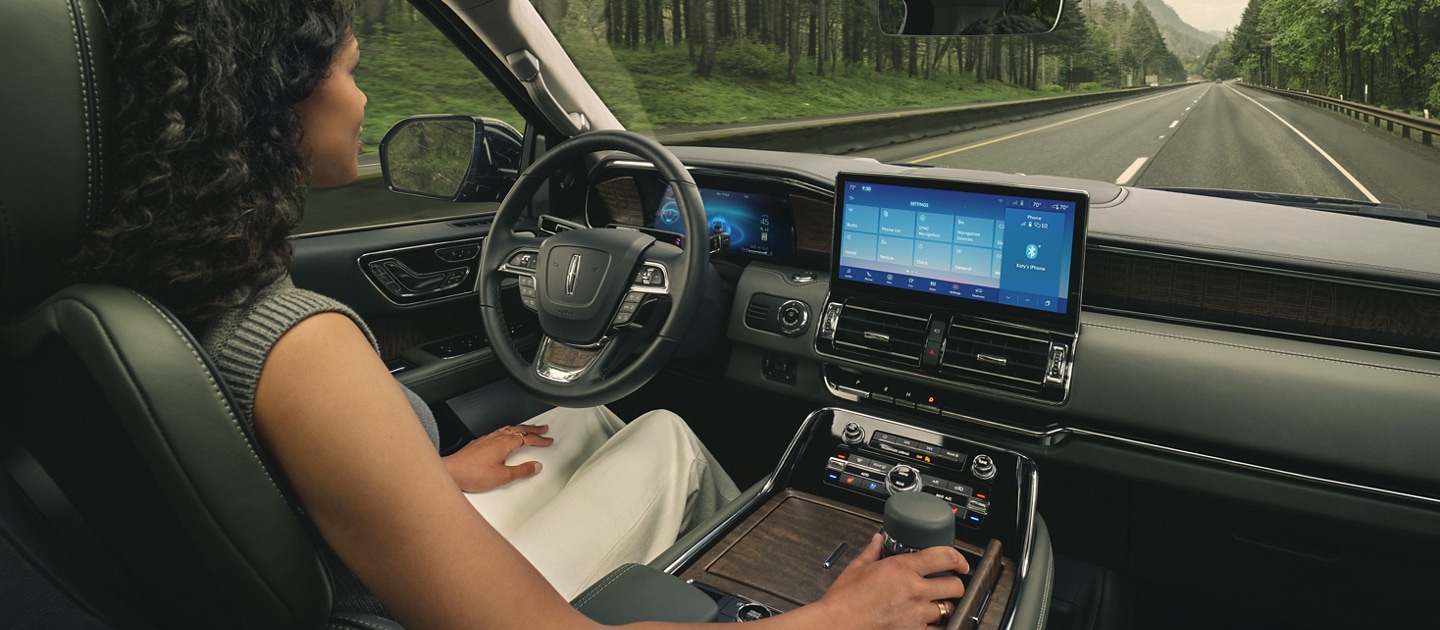 A driver of a 2024 Lincoln Navigator SUV relaxes with hands-free driving technology engaged