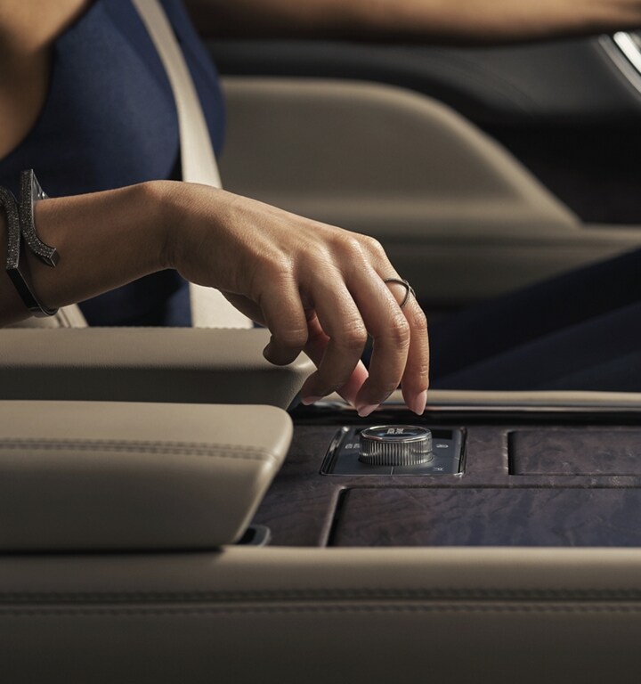 A hand is about to turn the Lincoln drive modes knob in the centre console