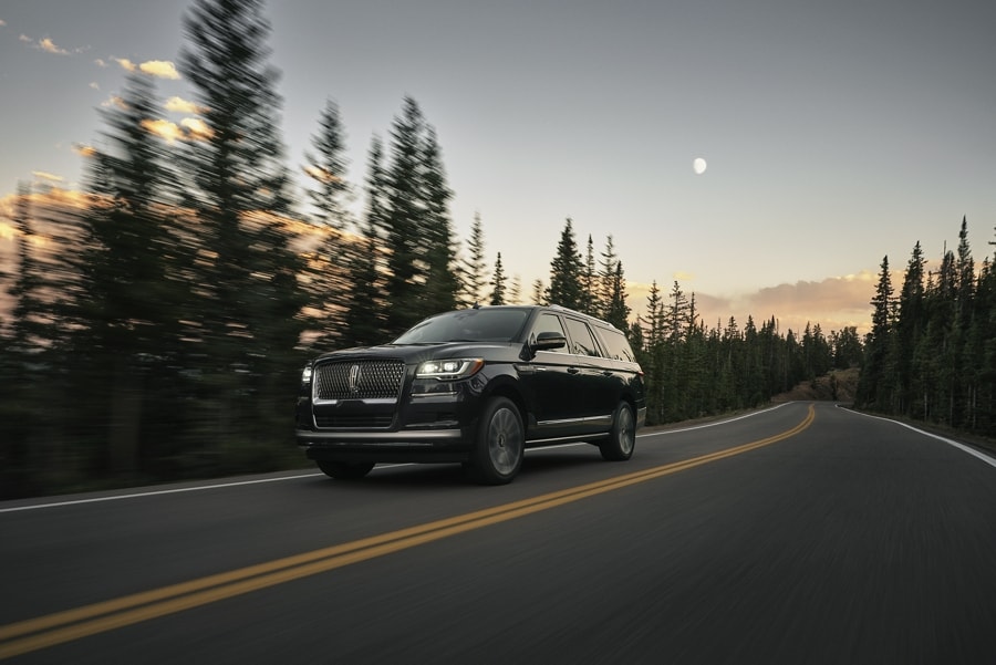 A 2024 Lincoln Navigator SUV is being driven a mountain road