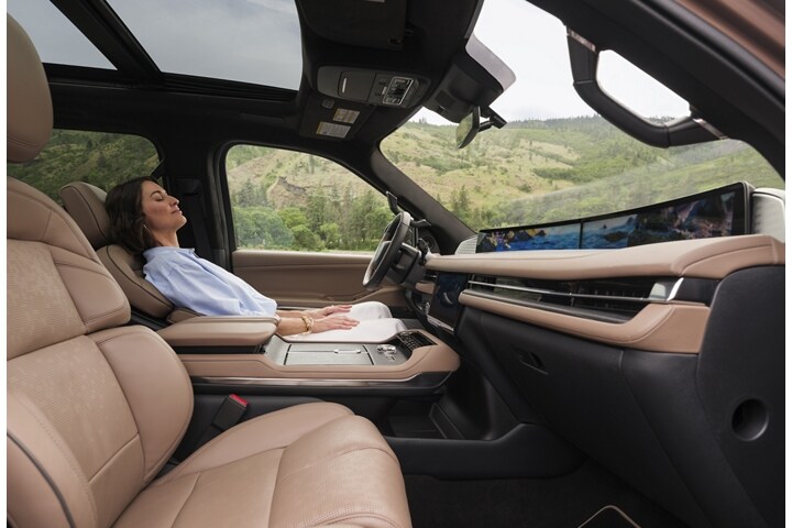 A woman enjoys the Lincoln Rejuvenate experience while seated in a parked 2025 Lincoln Navigator SUV