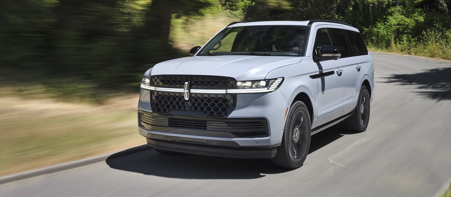 A 2025 Lincoln Navigator is being driven on a country road