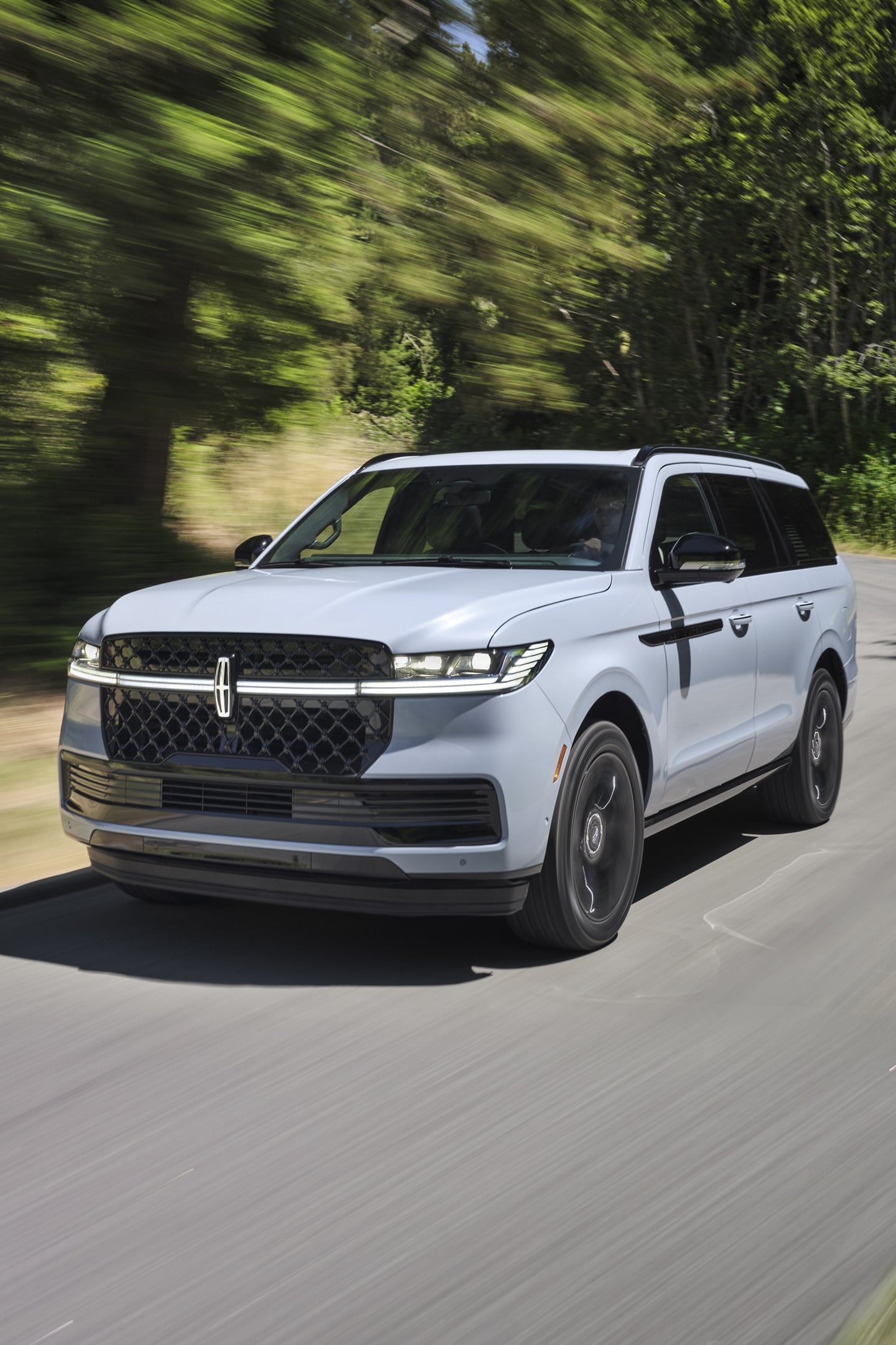 A 2025 Lincoln Navigator is being driven on a country road