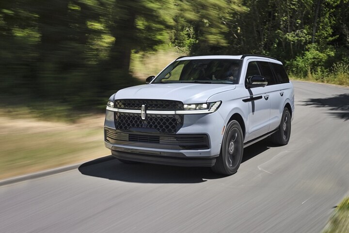 A 2025 Lincoln Navigator is being driven on a country road
