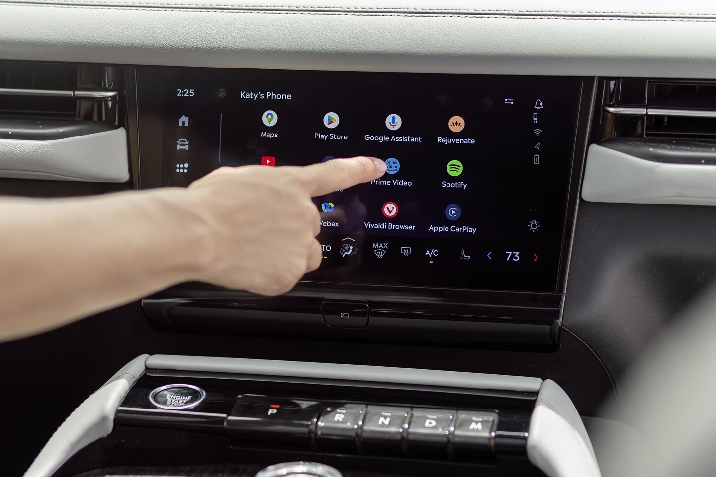 A finger presses a button on the centre touch screen inside a 2025 Lincoln Navigator®