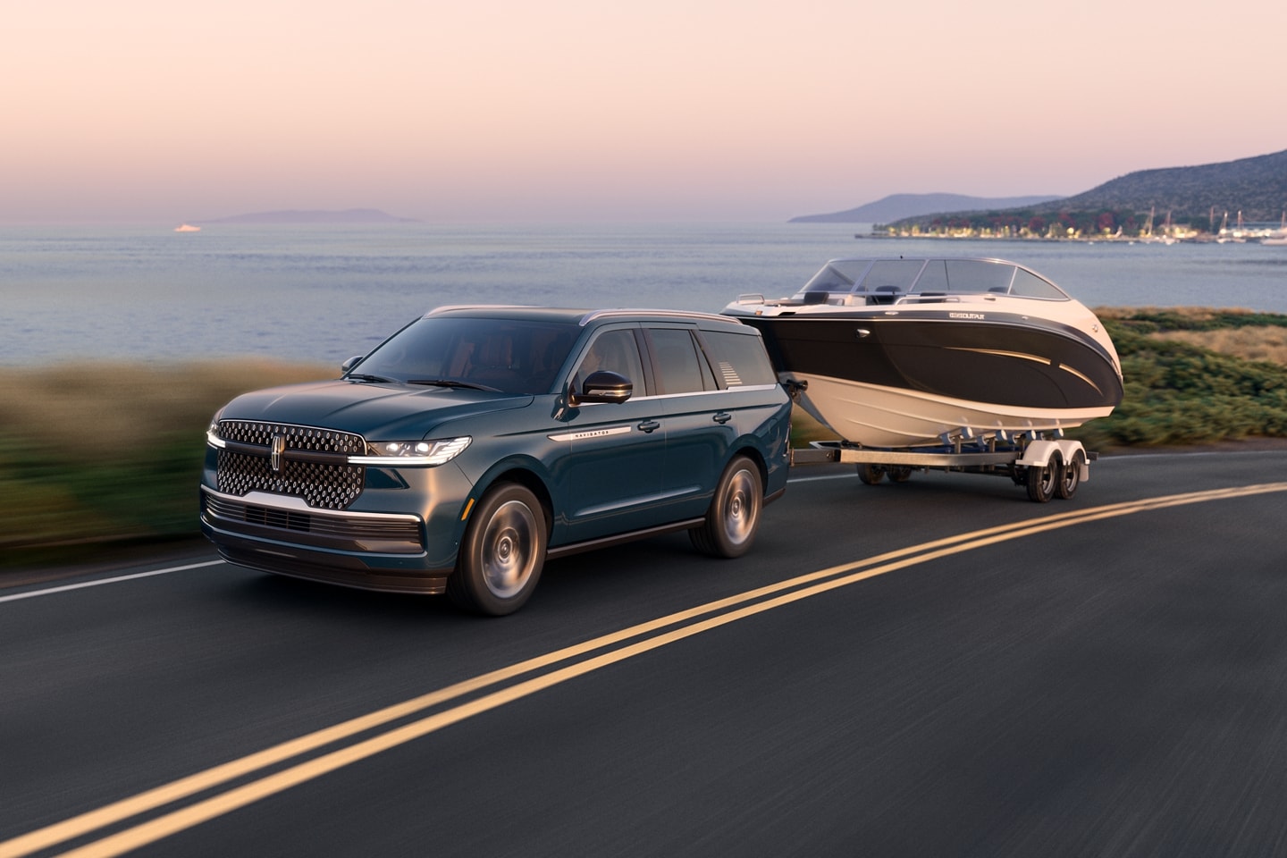 A 2025 Lincoln Navigator is towing a large boat near a body of water
