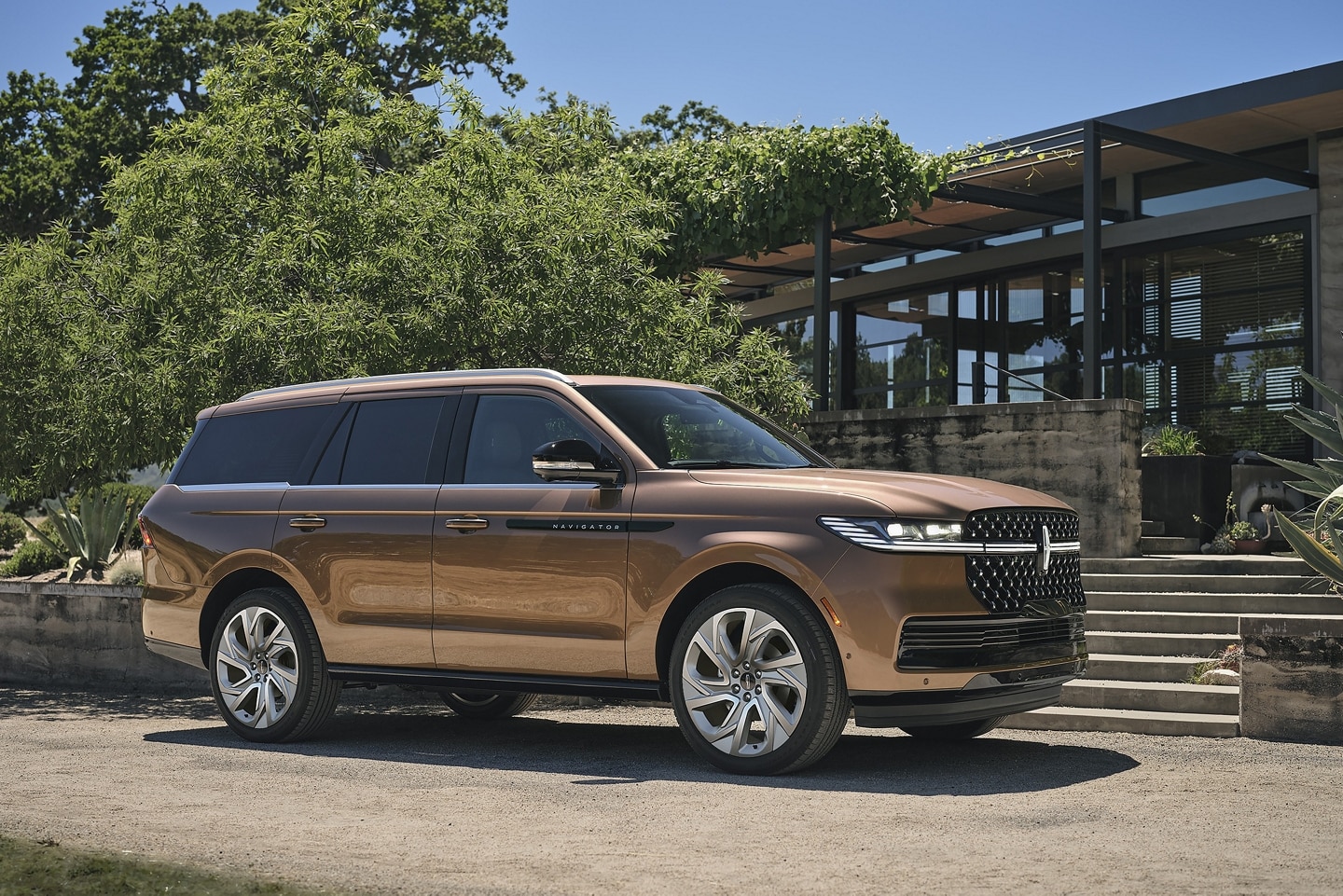 A 2025 Lincoln Black Label Navigator® SUV is parked in the driveway of a modern home