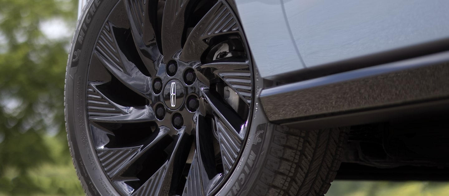 The 22" High Gloss Ebony Black aluminum wheel of a 2025 Lincoln Navigator Reserve with Jet Appearance Package