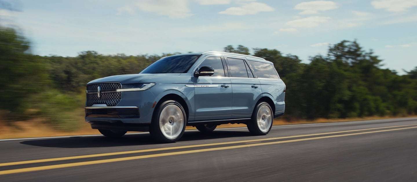 A 2025 Lincoln Navigator is being driven on a country road