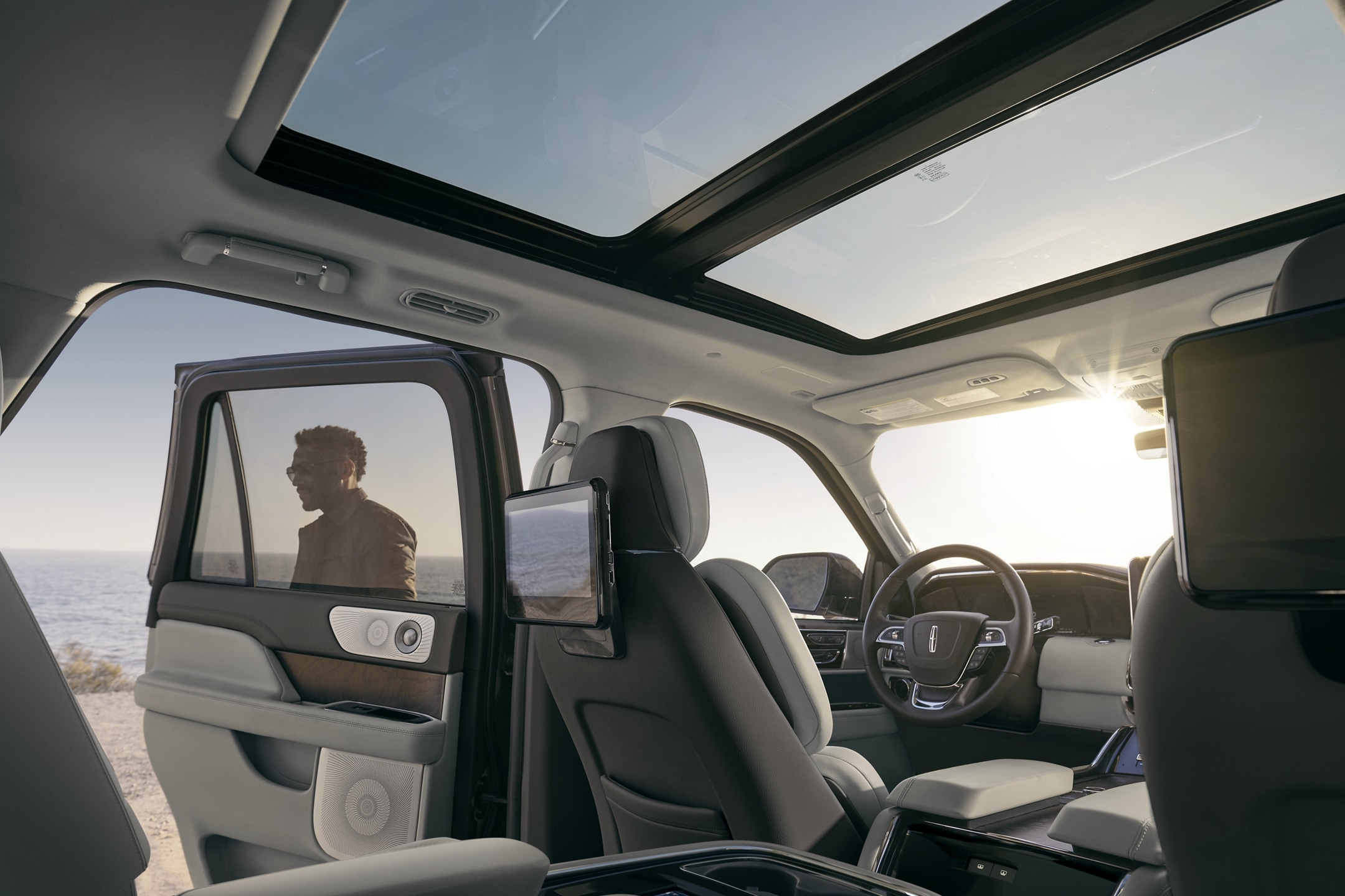 Blue skies are seen through the expansive Panoramic Vista Roof® as sunlight illuminates the broad cabin with a warm glow